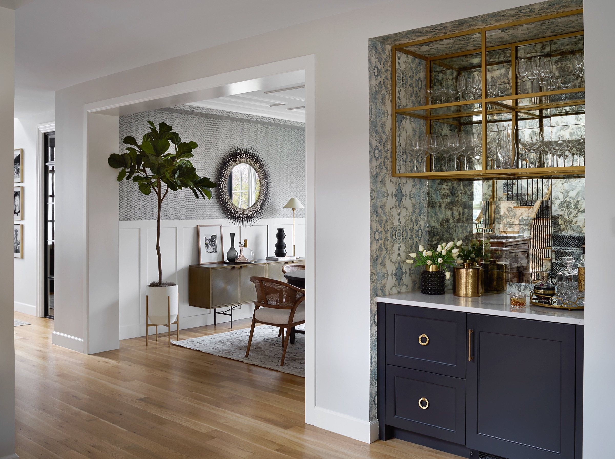 Dining room with black oval table, woven-back chairs, and gold-and-glass chandelier in the Bonnie Brae whole home renovation